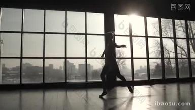 一个优雅的芭蕾舞演员的剪影与古典芭蕾舞蹈和高弹跳在阳光下。慢动作